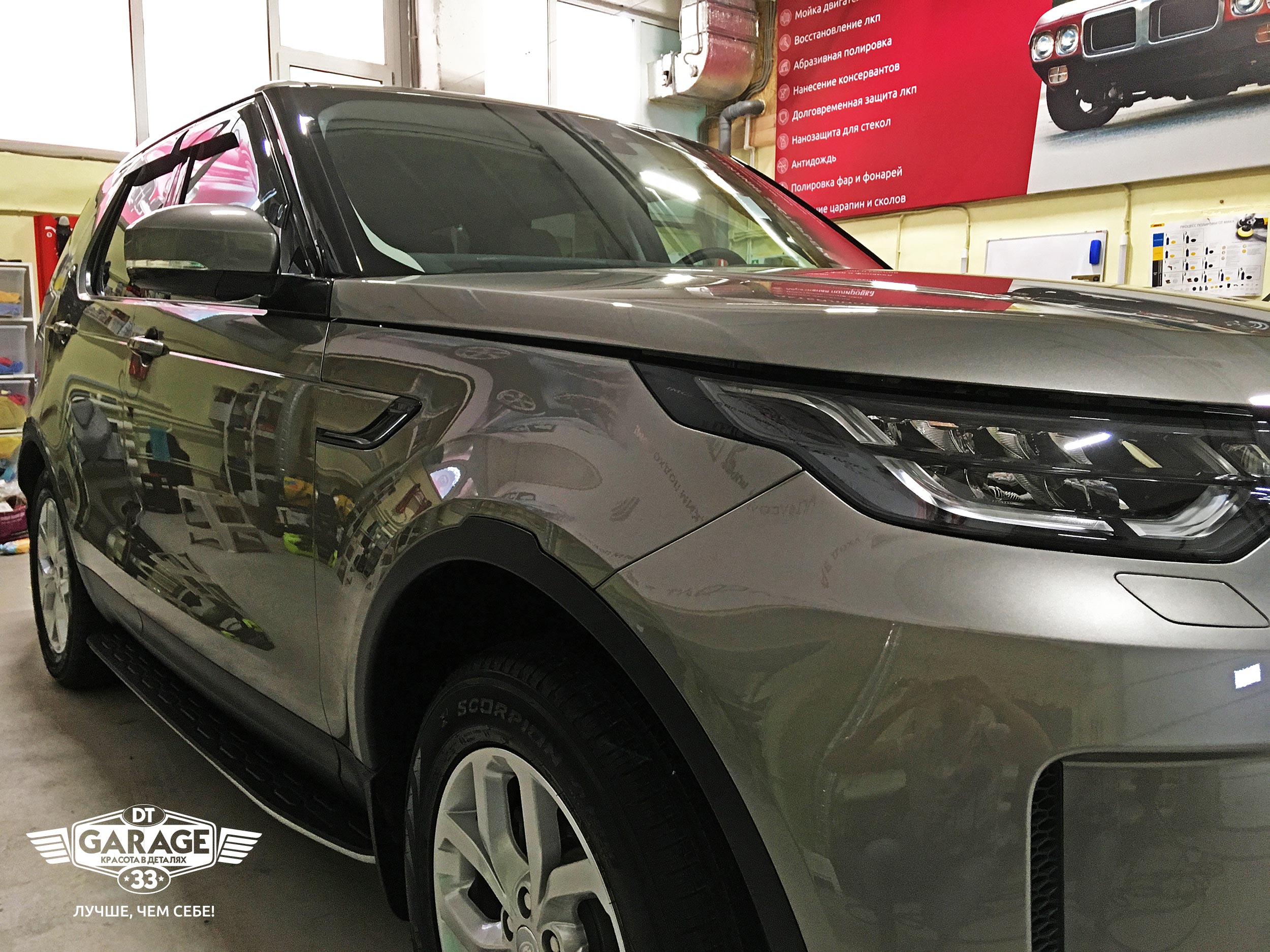 На фото крупным планом правый борт автомобиля Land Rover Discovery 5 с ярким отражением.
