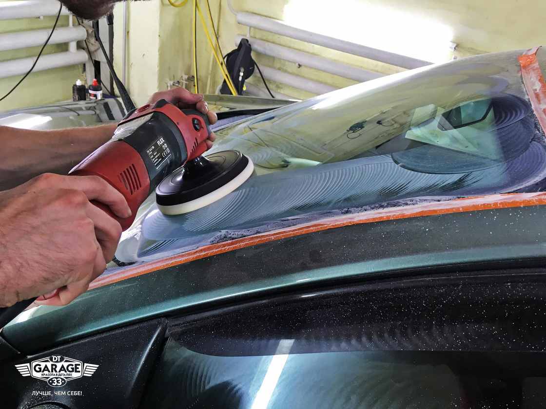 На фото мастер ателье «DT GARAGE 33» полирует стекло у автомобиля BMW.