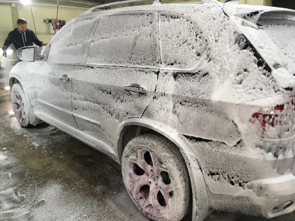 На фото BMW X5, обработанный моющим составом для первой фазы.