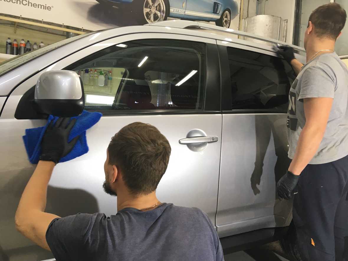 На фото два мастера «DT GARAGE 33» за работой. Они наносят жидкое стекло на Mitsubishi Outlander.