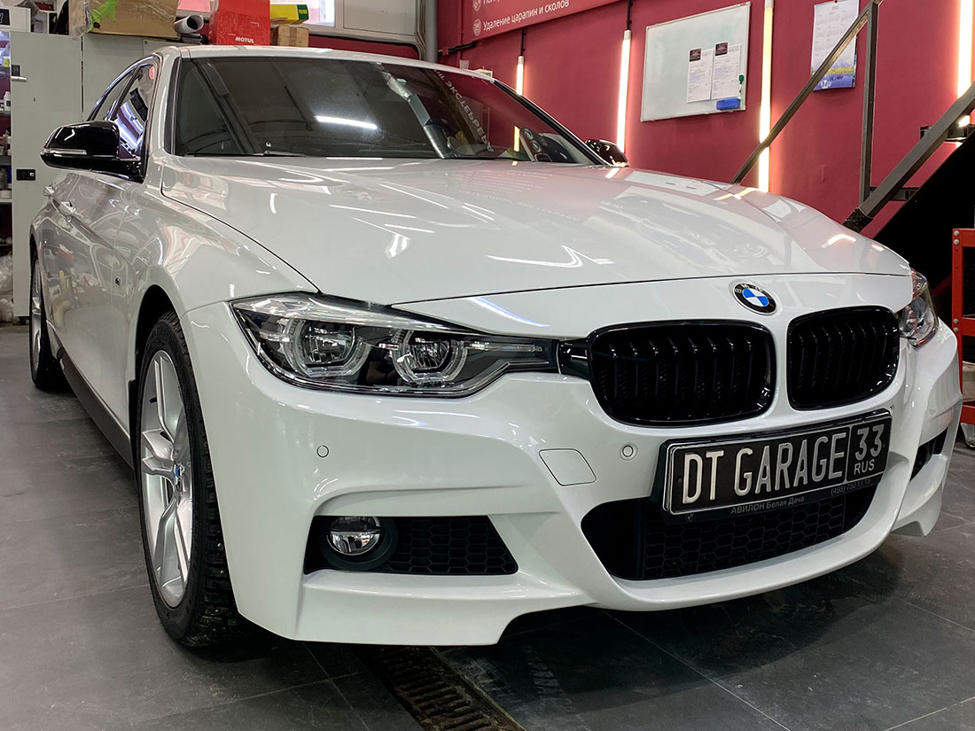 На фото BMW 3 белого цвета после замены старой антигравийной пленки на новую.