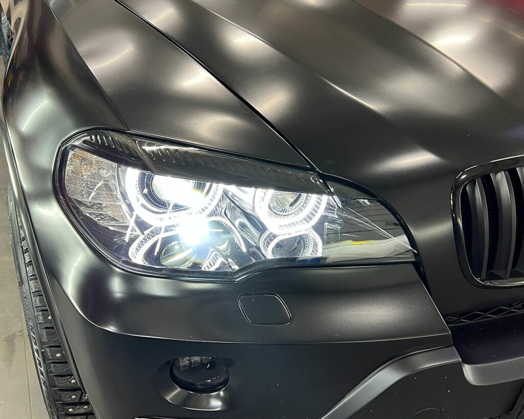 Смотреть на фото автомобиль BMW X5 с нестандартными лазерными фарами.